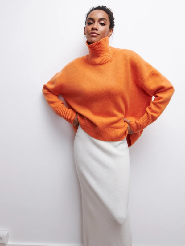 Orange knitted turtleneck sweater with long sleeves, ribbed cuffs, and hem