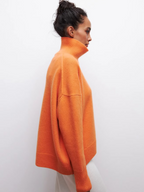 Orange knitted turtleneck sweater with long sleeves and ribbed collar