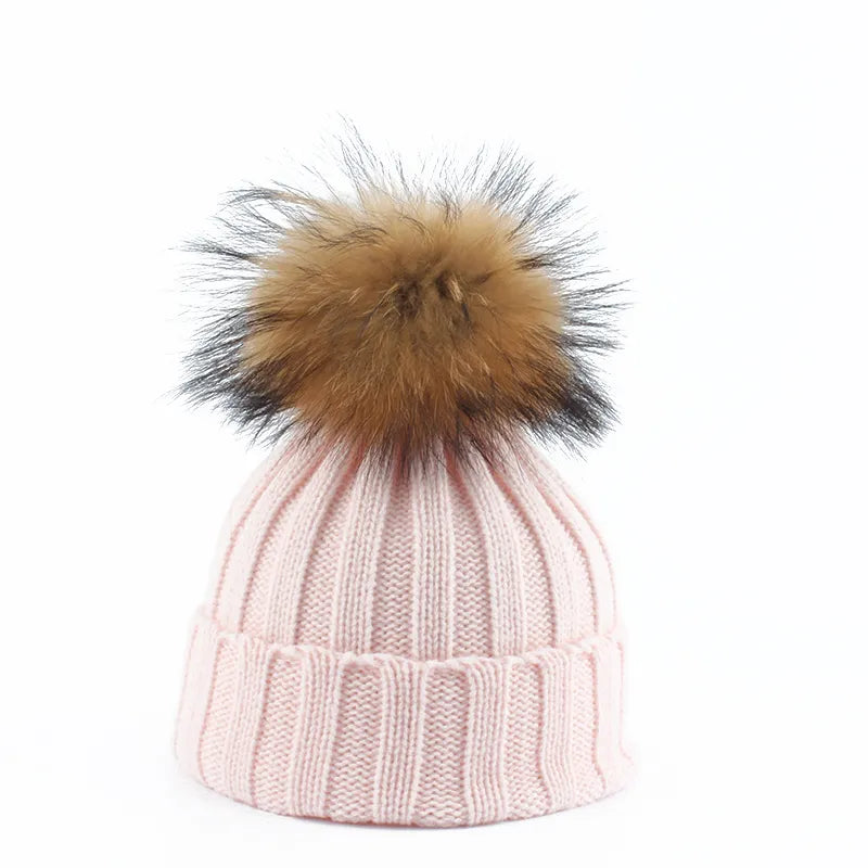 Knit beanie hat with tan pom-pom, ribbed texture, pale pink color