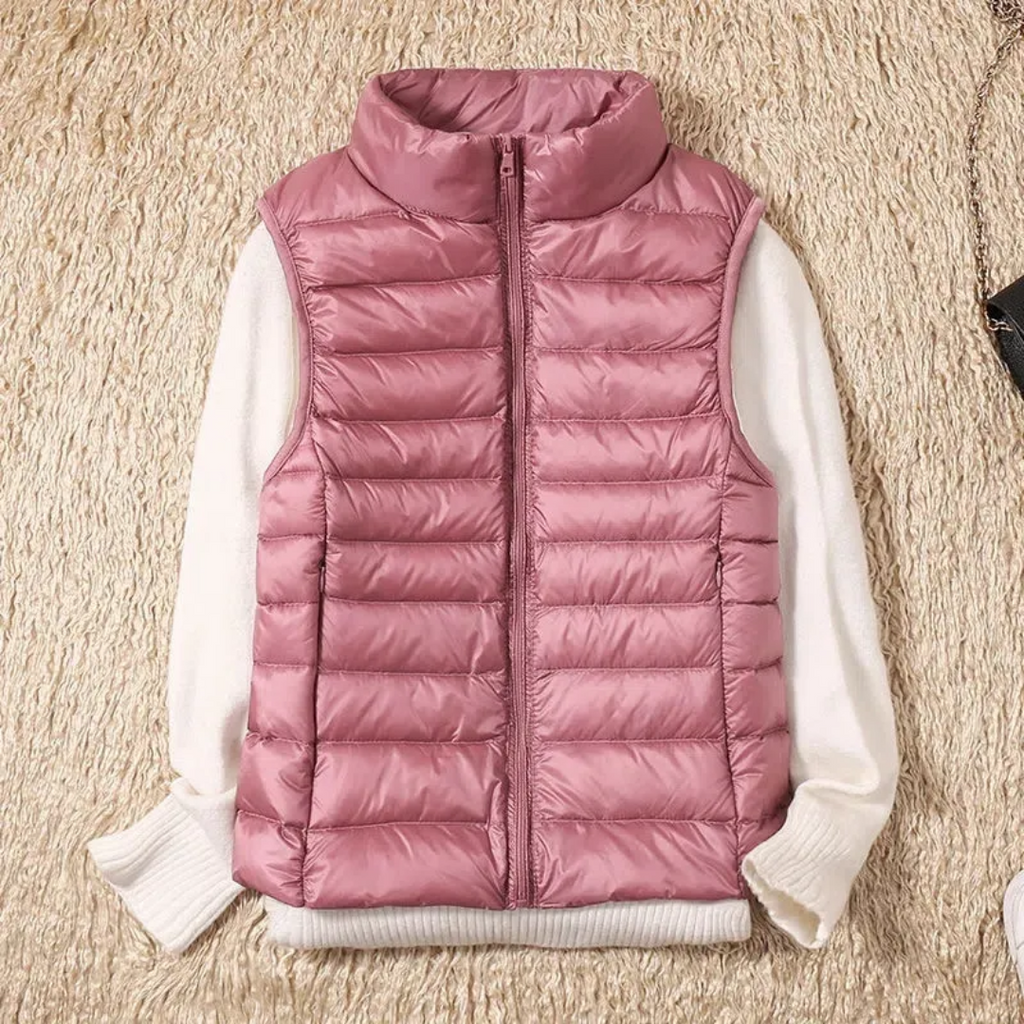 Rose-pink quilted bodywarmer vest with full-zip and stand collar over white sleeves