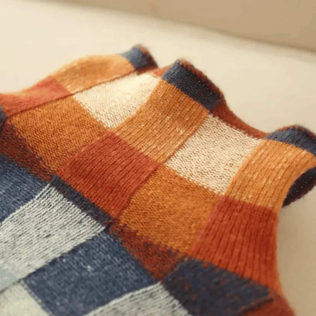 Patchwork turtleneck sweater knit close-up with orange, teal, white, and dark blocks