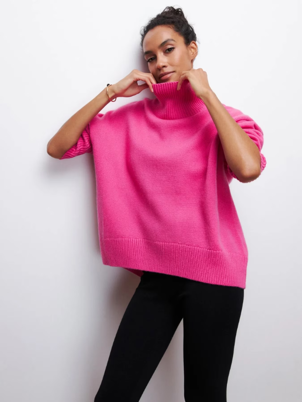 Bright pink knitted turtleneck sweater with folded sleeves and ribbed hem