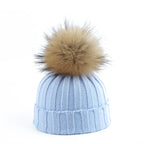Knit beanie hat with tan pom-pom, ribbed texture, light blue color
