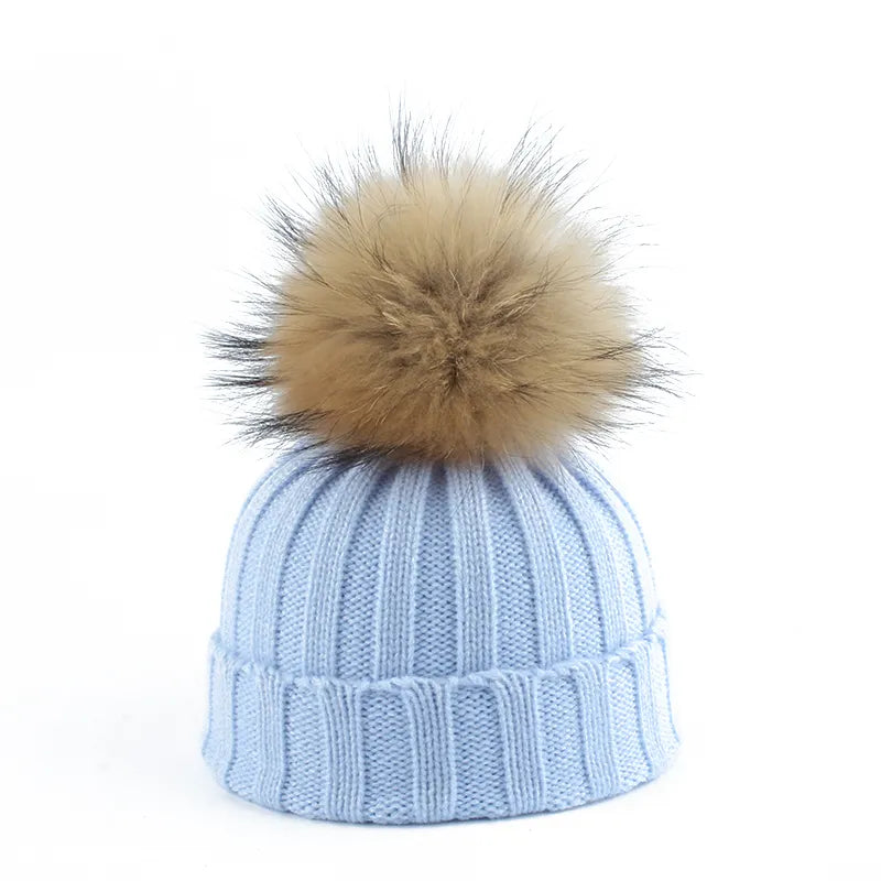 Knit beanie hat with tan pom-pom, ribbed texture, light blue color