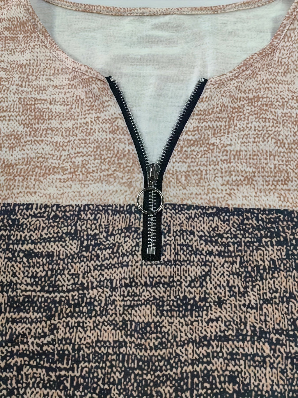 Quarter-zip sweater placket with black zipper pull and ring, heather tan and charcoal stripe