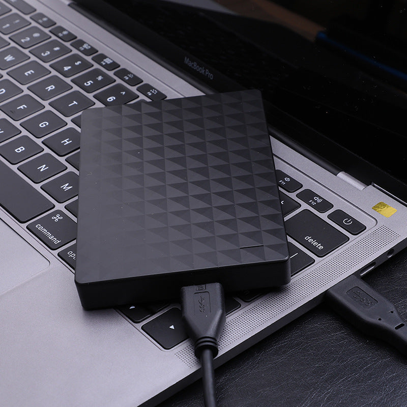 Ultra-thin portable hard drive with black geometric surface and connected USB cable