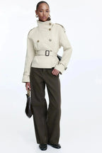 Light beige trench coat with stand-up collar and tied waist belt, double-breasted