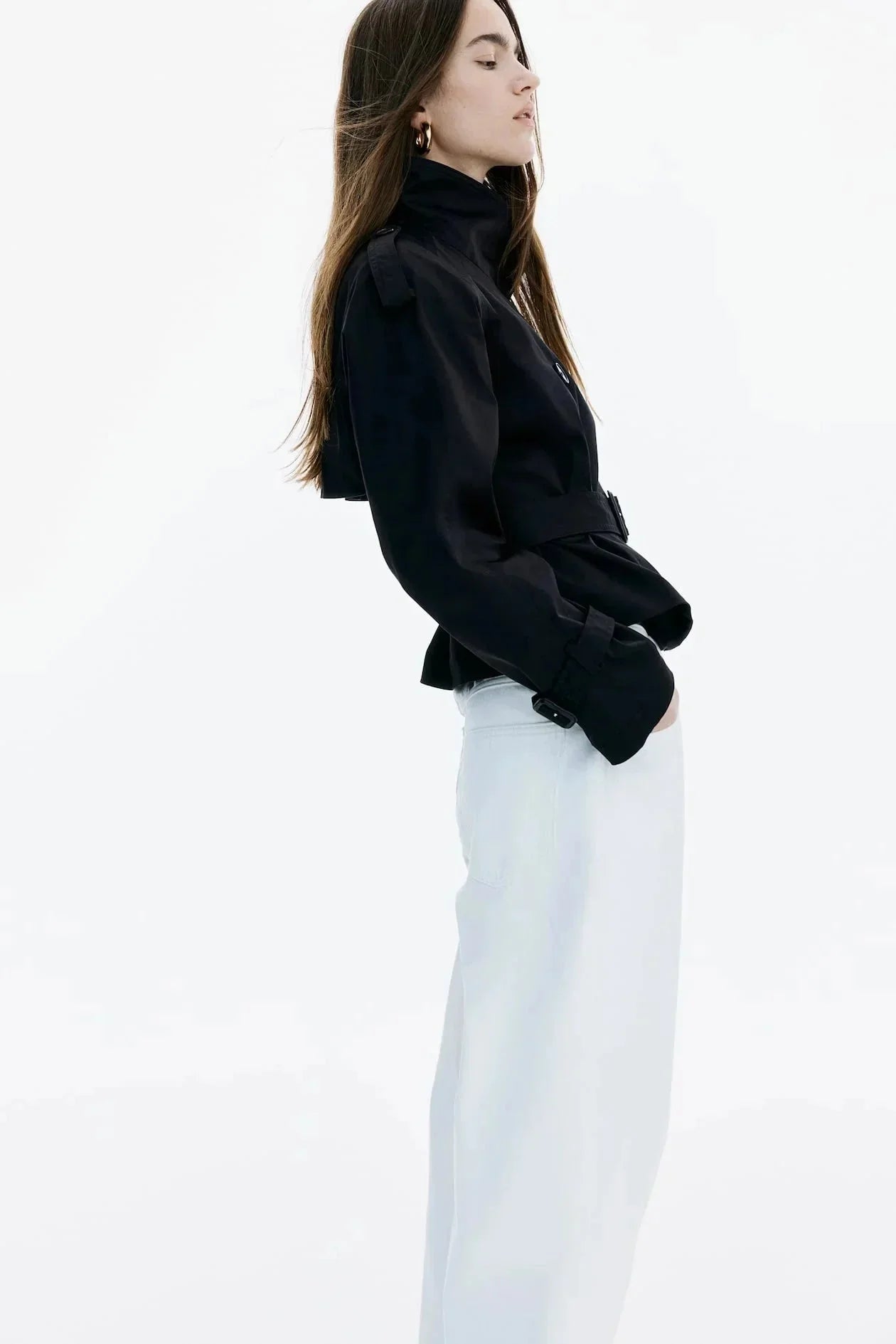 Black trench coat side view with stand-up collar and buttoned front