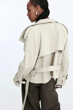 Light beige trench coat back view with stand collar and tied belt at waist