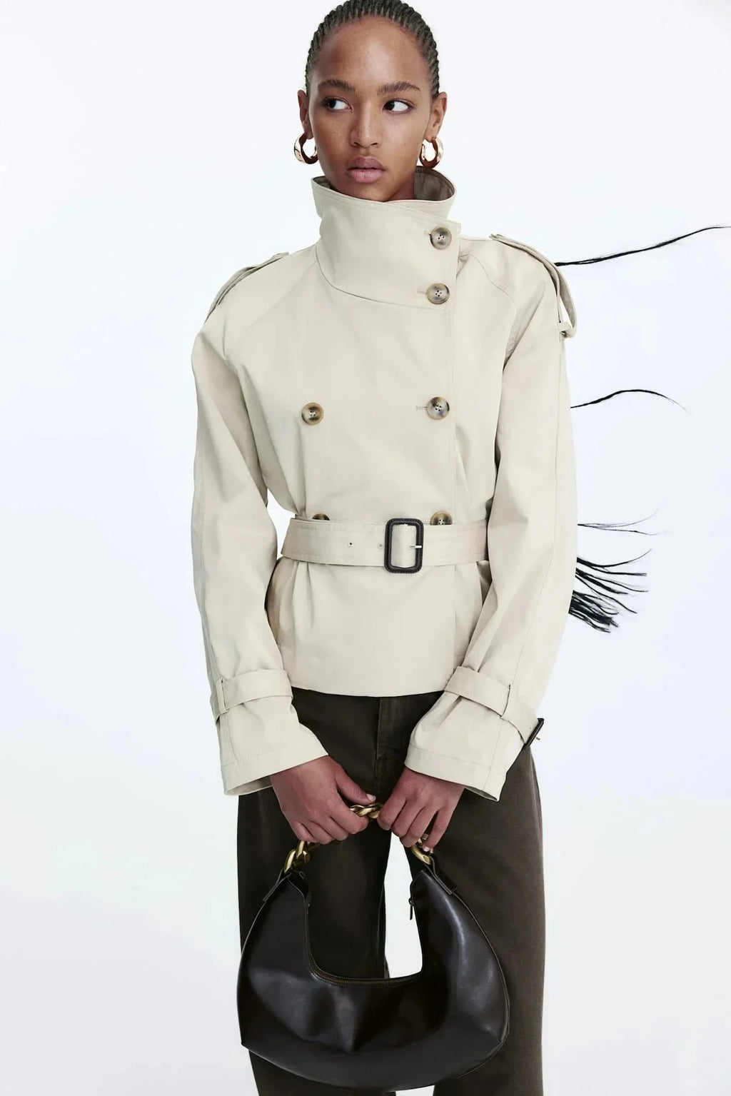 Light beige trench coat with stand collar, double-breasted buttons, and tied belt