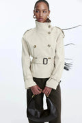 Light beige trench coat with stand collar, double-breasted buttons, and tied belt