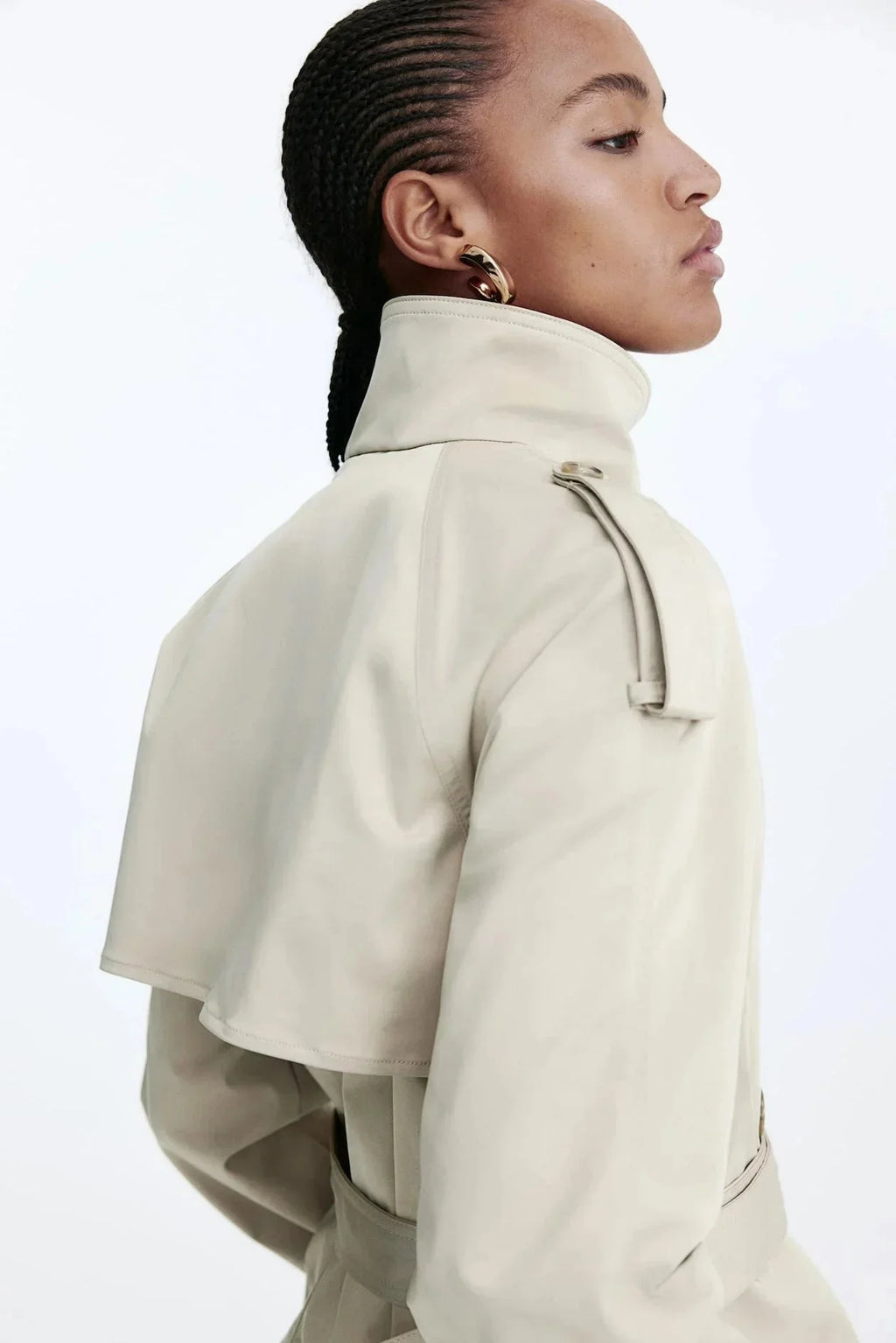 Light beige trench coat side view with stand-up collar and tied waist belt