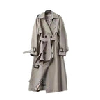 Women’s long trench coat with belt and lapels in light gray, plaid lining visible.