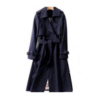 Women’s long trench coat with belt and lapels in navy blue, plaid lining visible.