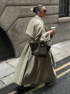 Olive oversized trench coat with wide lapels and belted waist, long length