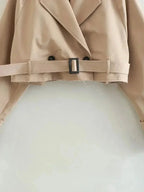 Light-brown trench coat belt with buckle and black button details, front view