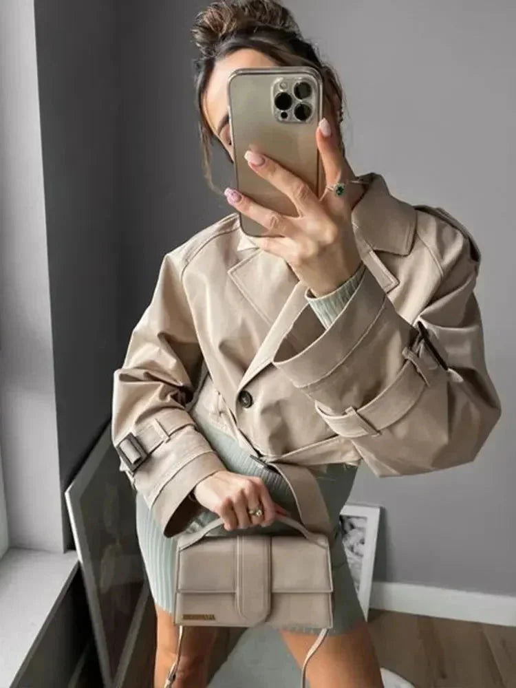 Women’s short light-brown trench coat with long sleeves, belt and lapel collar