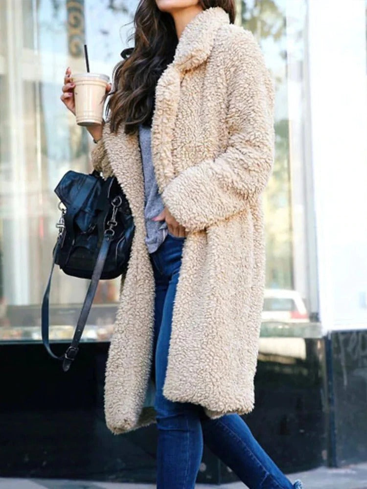 Long teddy coat in cream-beige fuzzy fabric, open front with soft collar.