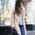 Long teddy coat in cream-beige fuzzy fabric, open front with plush collar.