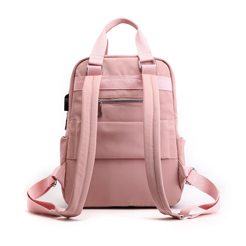 Pink backpack with front zip pocket, two side compartments, and adjustable shoulder straps