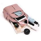 Pink backpack with top open compartment holding electronics and small accessories