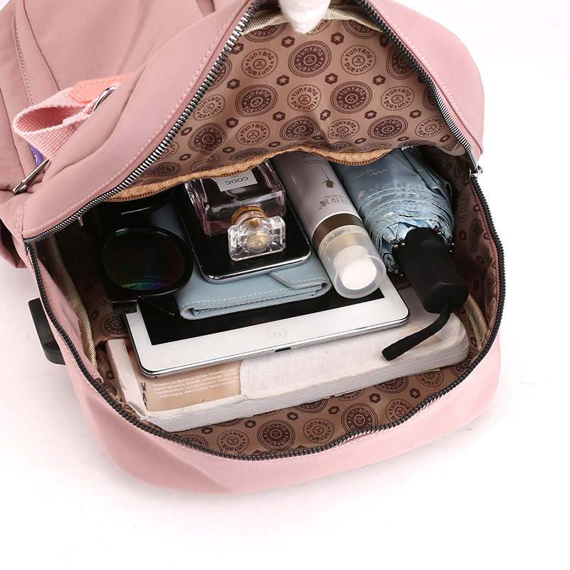 Pink backpack interior with patterned lining and multiple zip and slip pockets