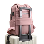 Pink water-resistant backpack with front pockets and side zippers, plus trolley strap