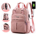 Light pink water-resistant backpack with USB charging port, padded handles, front zip pocket