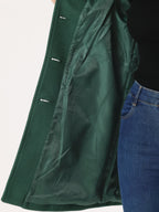 Green coat lining detail with button placket and side slit visible near hem