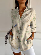 Abstract print split-neck button blouse with long sleeves, light fabric with bird and plant motifs