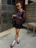 Women’s burgundy faux leather bomber jacket with front zipper and ribbed cuffs