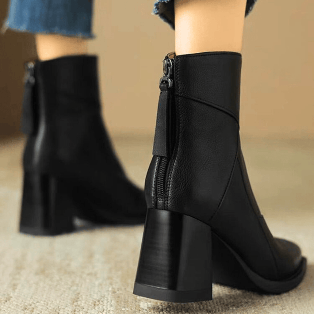 Black ankle boots with stacked block heel, side zipper, and wide seam stitching