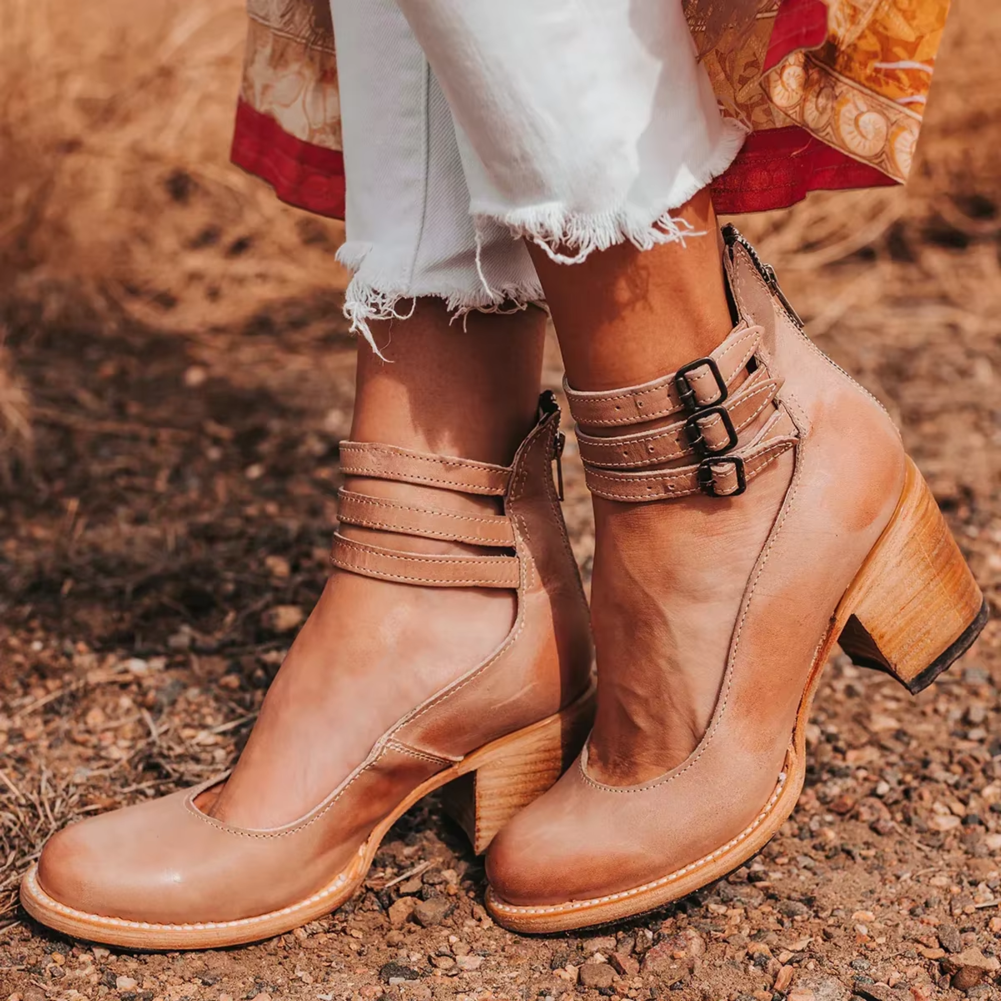 Tan leather ankle-strap shoes with double buckle straps and wooden block heel.