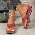 Women's wedge sandals in red with floral appliques, cushioned footbed, thong toe