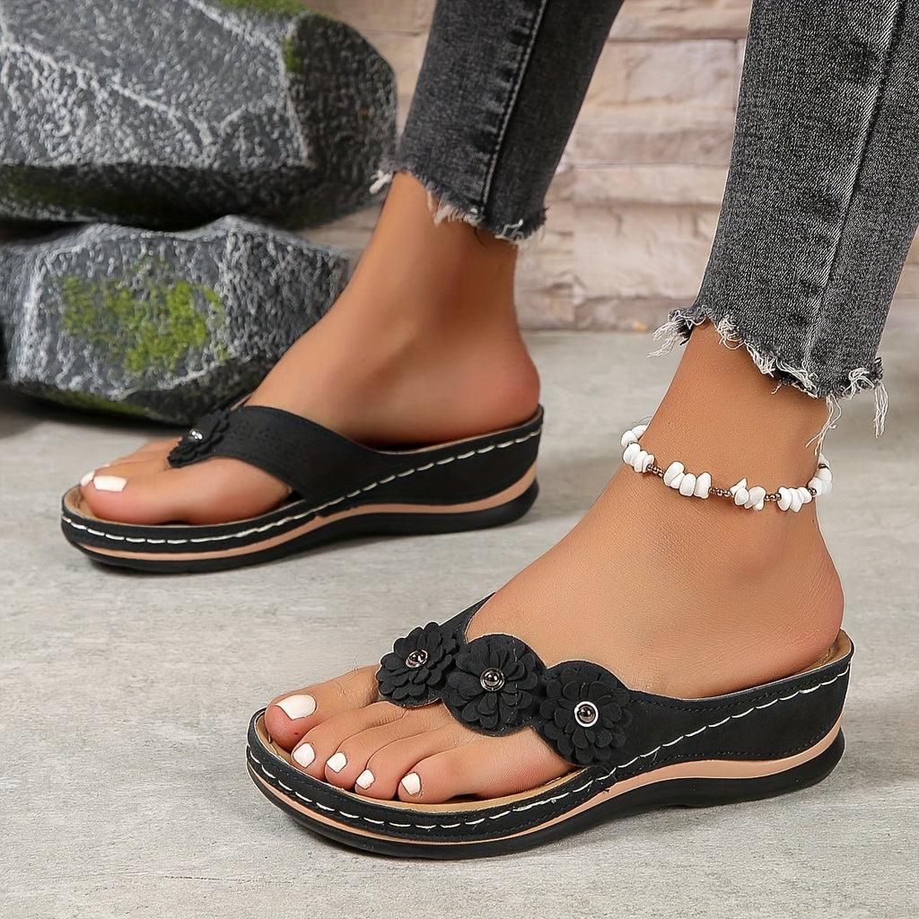Women's wedge sandals in black with flower toe applique and white beaded ankle strap