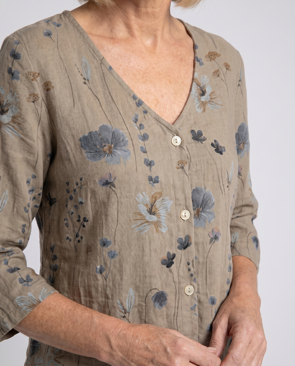 Women's three-quarter sleeve blouse close-up, khaki V-neck with floral button placket
