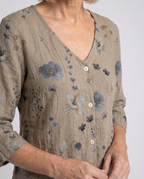 Women's three-quarter sleeve blouse close-up, khaki V-neck with floral button placket