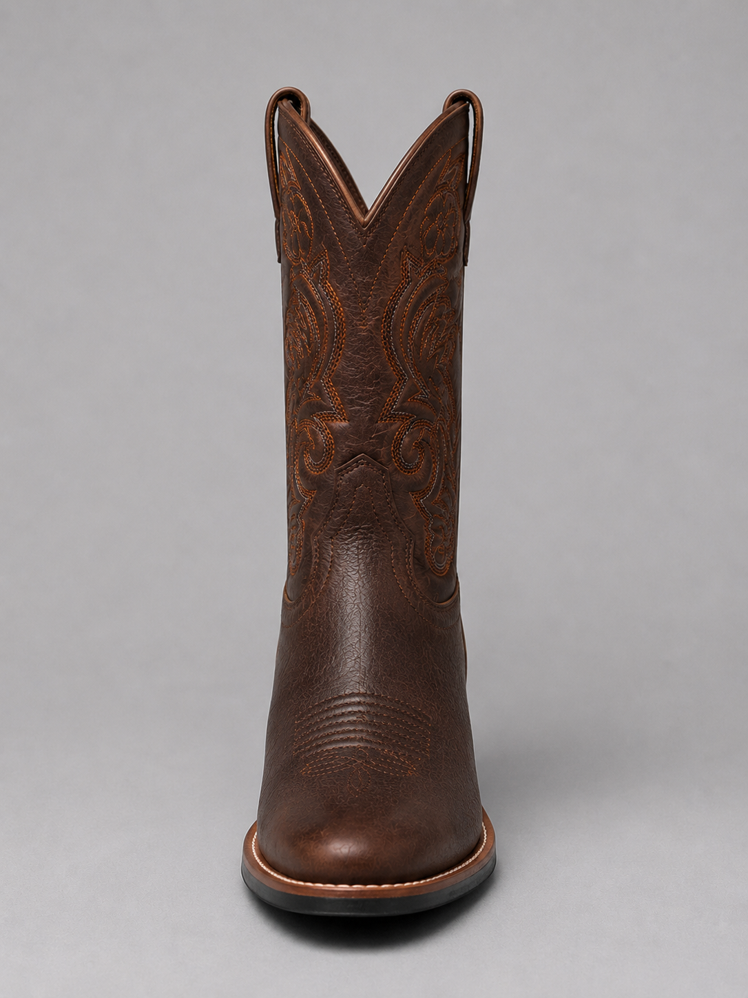 Brown leather cowboy boots with ornate stitched V-top and decorative shaft