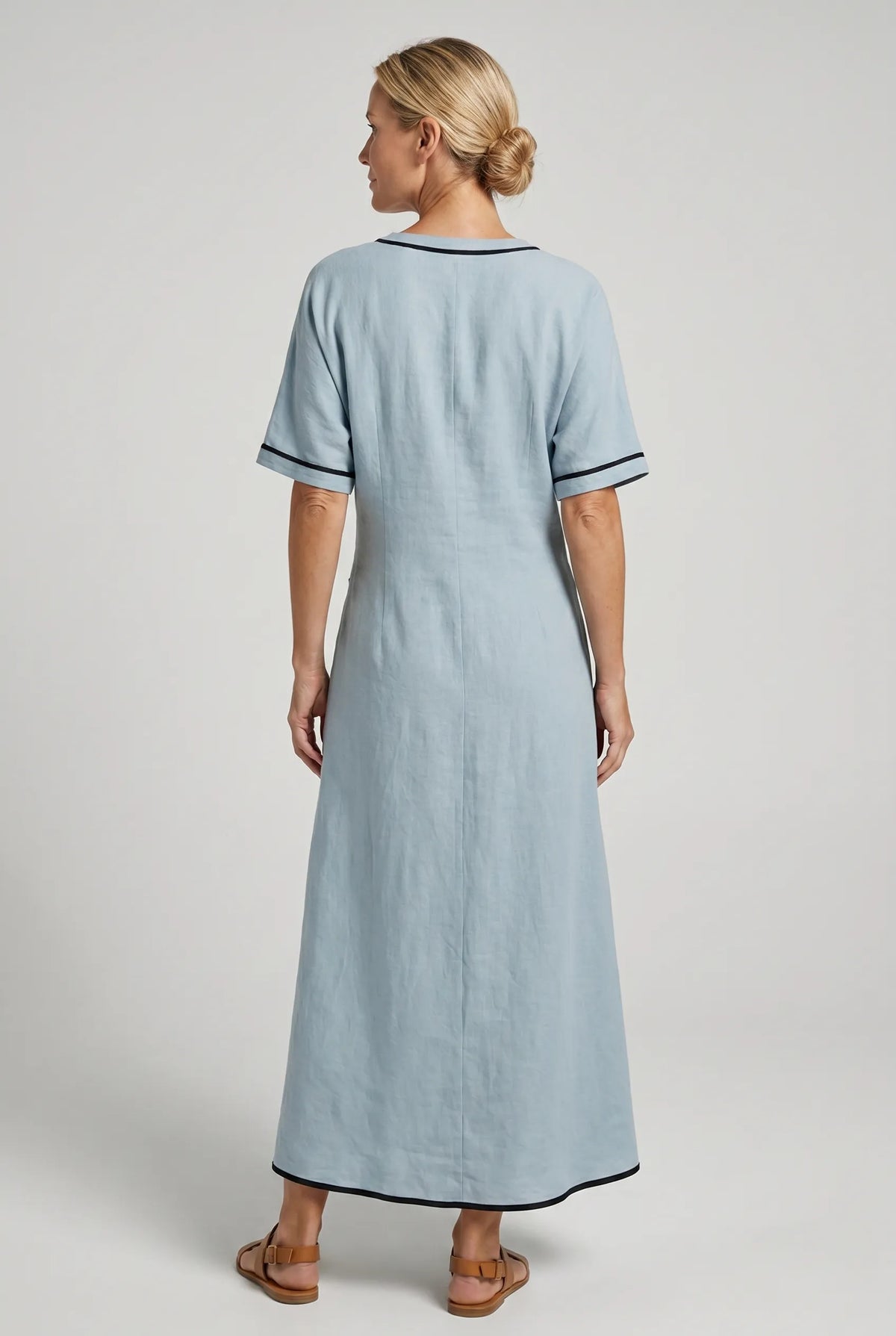 Women's twist-front maxi dress back view, blue, short sleeves, black-trim neckline and knot